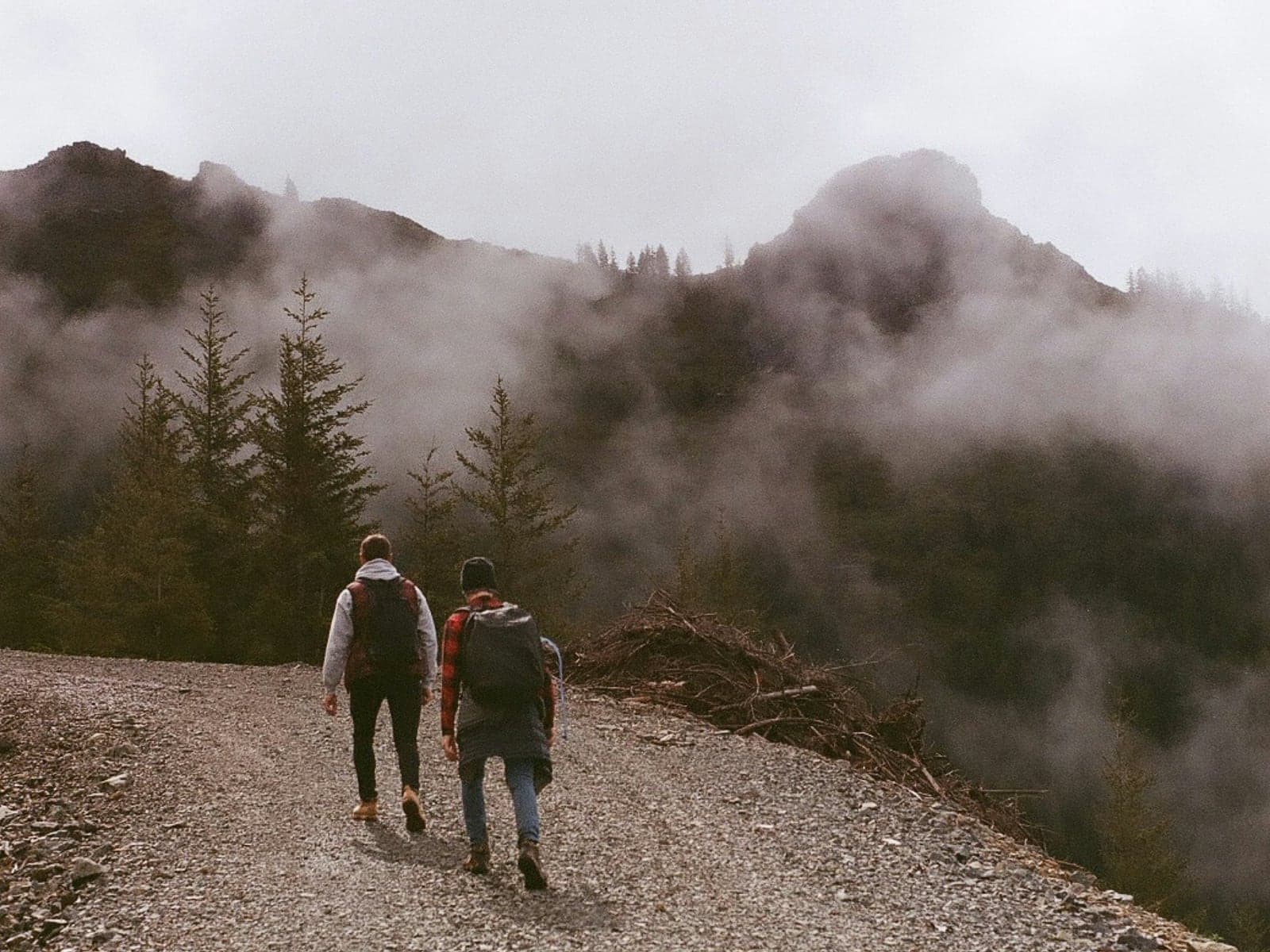 Two people walking a mountain road together as the cloud comes in.